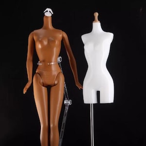May include: Two mannequins, one with a brown body and the other with a white body, both headless and standing on clear plastic stands. The mannequins are used for displaying clothing and accessories.