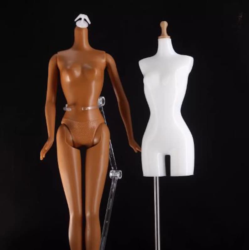 May include: Two mannequins, one with a brown body and the other with a white body, both headless and standing on clear plastic stands. The mannequins are used for displaying clothing and accessories.
