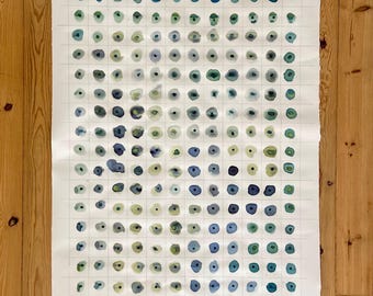 May include: A white sheet of paper with a grid pattern. Each square contains a hand-painted blue, green, and gray circle.