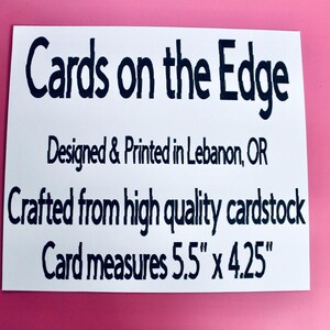 May include: White rectangular card with black text that reads "Cards on the Edge." The card is designed and printed in Lebanon, OR, and crafted from high-quality cardstock. The card measures 5.5" x 4.25". The background is pink.
