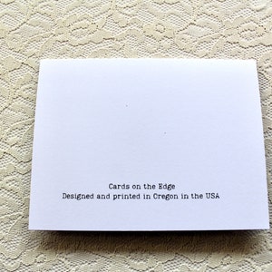 Peut inclure: Une carte blanche avec le texte "Cards on the Edge" et "Designed and printed in Oregon in the USA".