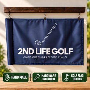 May include: A navy blue rectangular banner suspended from a dark wood horizontal mount with three metal clips. The banner features a white line drawing of a golf club, the text 2ND LIFE GOLF, and the phrase GIVING OLD CLUBS A SECOND CHANCE.