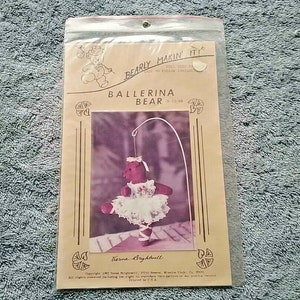 May include: A vintage craft pattern for making a ballerina bear. The pattern is printed on a cream-colored paper with a brown border. The pattern includes instructions and a picture of a finished ballerina bear.