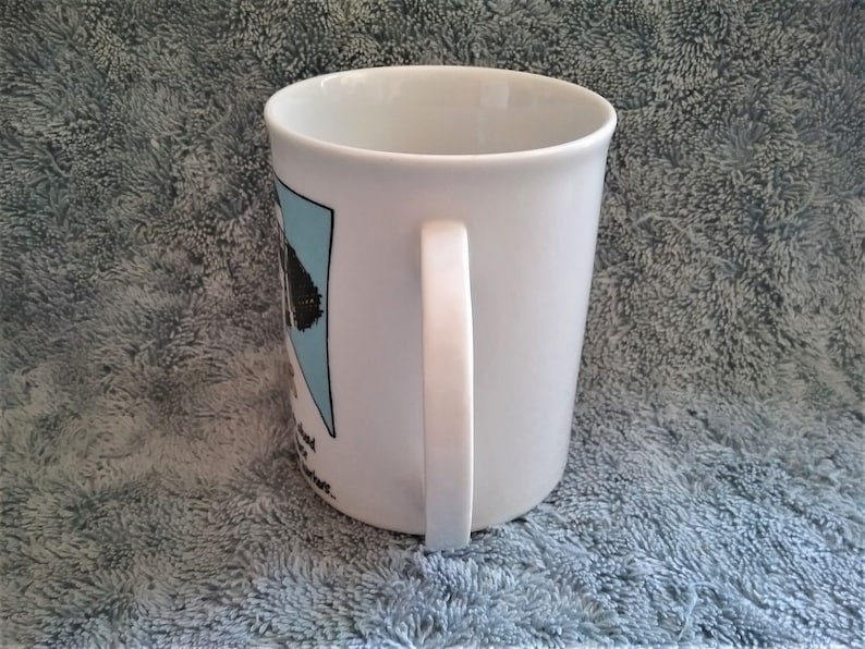 K&ouml;nnte beinhalten: Wei&szlig;e Keramiktasse mit einer schwarz-wei&szlig;en Cartoon-Illustration eines Hundes mit Hut und Sonnenbrille. Der Text "Ich bin kein Hunde-Mensch, ich bin ein Hunde-Besessener" ist auf die Tasse gedruckt.