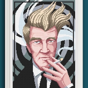Può includere: Ritratto a punto croce incorniciato di un uomo con capelli biondo chiaro, che indossa un abito e una cravatta neri, con in mano una sigaretta accesa. Lo sfondo presenta un design geometrico nero e grigio con elementi bianchi simili a fumo.