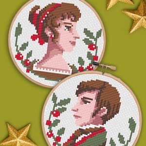 May include: Two cross-stitch embroidery hoops featuring portraits of a woman and a man. The woman has brown hair and is wearing a red ribbon. The man has brown hair and is wearing a green jacket. Both portraits are surrounded by a wreath of green leaves and red berries.