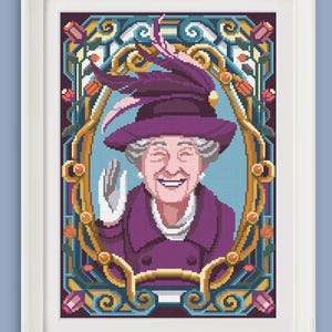 May include: A framed cross-stitch portrait of a smiling woman in a purple hat and coat, waving. The portrait is set within an ornate gold and teal frame, with floral and scrollwork details. The background is a light blue.