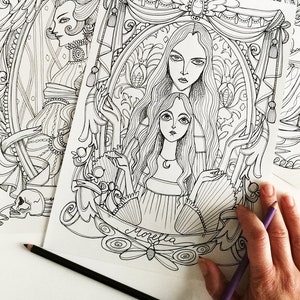 Può includere: Un disegno in bianco e nero di due donne con i capelli lunghi, una con una corona, in una cornice ornata. La parola "Moretta" è scritta sotto la cornice.