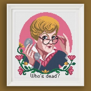 Può includere: Opera d'arte a punto croce incorniciata in bianco, raffigurante una donna bionda con occhiali che tiene un telefono. L'immagine include uno sfondo rosa e dettagli floreali, con il testo "Who's dead?"