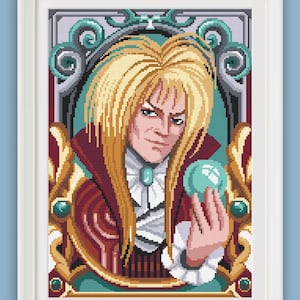 May include: Cross-stitch portrait of a character with long blonde hair, wearing a burgundy coat with a white ruffled collar, holding a teal orb. The artwork is framed in a white border, with a teal and gold decorative border.
