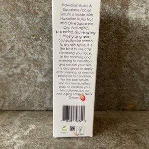 May include: A white box of Hawaiian Kukui & Squalane facial serum. The text on the box describes the product's ingredients and benefits, including anti-aging and moisturizing properties. The box also includes a barcode and other product information.