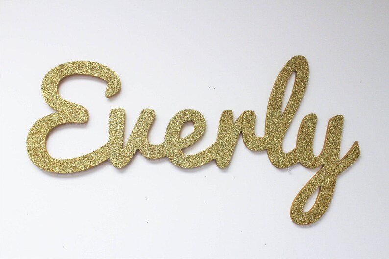 May include: Gold glitter letters spelling out the name "Everly".
