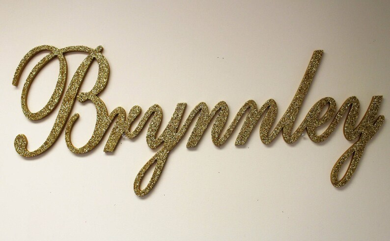 May include: Gold glitter letters spelling out the name "Brynnley".