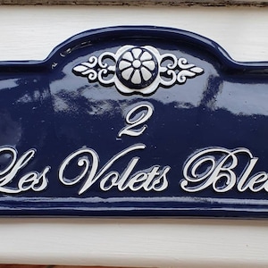 Puede incluir: Un letrero de n&uacute;mero de casa azul y blanco con el n&uacute;mero 2 y el texto "Les Volets Bleus".