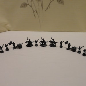 May include: A set of 18 black plastic toy soldiers, including infantry, cavalry, and artillery. The soldiers are arranged in a semi-circle on a white surface.