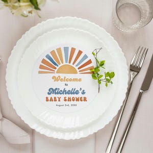 May include: A white plate with a colorful sunset design and the text "Welcome to Michelle's Baby Shower August 3rd, 20XX".