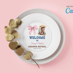 Puede incluir: Un plato blanco con un lazo rosa y una ilustración de botas de vaquero, con el texto "WELCOME to Jonny & Marli's GENDER REVEAL". El plato está sobre un plato blanco más grande, con hojas secas sobre un fondo rosa.