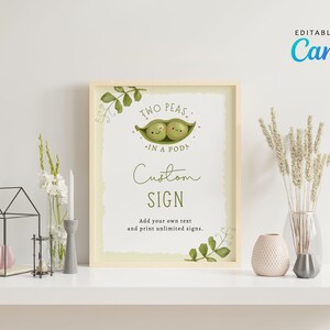 May include: A framed sign with the text "Two Peas in a Pod" and "Custom Sign". The sign has a light green background and a cartoon illustration of two peas in a pod. The sign is surrounded by decorative leaves.