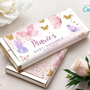 May include: A pink and white chocolate bar wrapper with a gold glitter background. The wrapper features a watercolor butterfly design and the text "Marie's Baby Shower 08/03, 20XX".