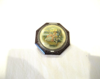 Estuche compacto de celuloide y metal con una pareja colonial, c. 1950.