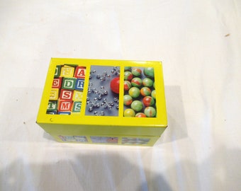 Yellow recipe box, marbles, jacks, blocks, yellow, c. 1980s by Syndicate Manufacturing