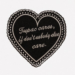 May include: Black heart-shaped patch with a white embroidered border and the text "Tupac cares, if don't nobody else care."