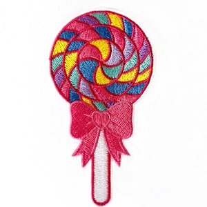 May include: Embroidered iron-on patch of a colorful lollipop with a pink bow. The lollipop is white, yellow, blue, green, and pink.