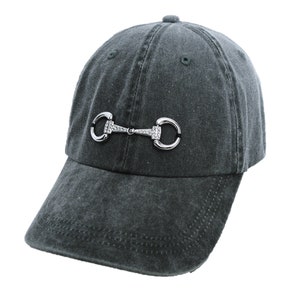 May include: A dark gray denim baseball cap with a silver metal horse bit design on the front.