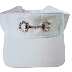 May include: White visor with a silver equestrian-style buckle with rhinestones.