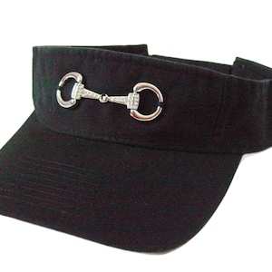 May include: A black visor with a silver equestrian-style buckle with rhinestones.