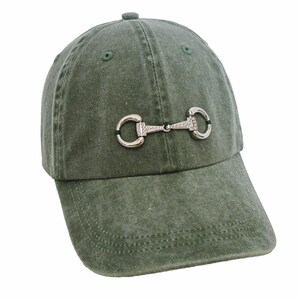 May include: A green cotton baseball cap with a silver metal equestrian-style bit detail.