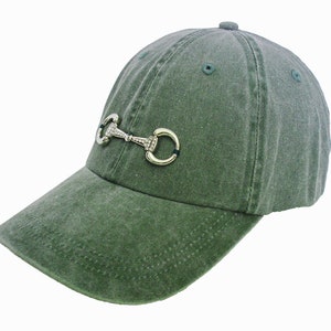 May include: A green baseball cap with a silver and rhinestone horse bit design.