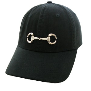 May include: A black baseball cap with a silver equestrian bit design featuring rhinestones.