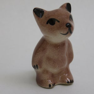 May include: A set of three ceramic mugs with a speckled, matte finish. The mugs are in shades of cream, light brown, and dark brown. Each mug has a simple, minimalist design, perfect for coffee or tea.