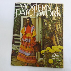 May include: A vintage magazine cover titled "Modern Patchwork" featuring a woman in a colorful patchwork outfit. The outfit includes a long skirt, shawl, and top in shades of orange, yellow, and purple. The background shows a garden setting.