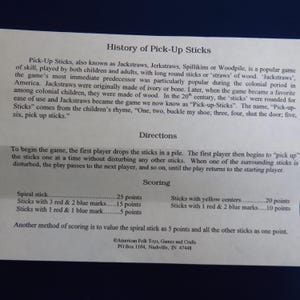May include: A printed sheet with the history, directions, and scoring for the game Pick-Up Sticks. The text includes details on the game's origins, rules, and point values for different stick types. The game is also known as Jackstraws.