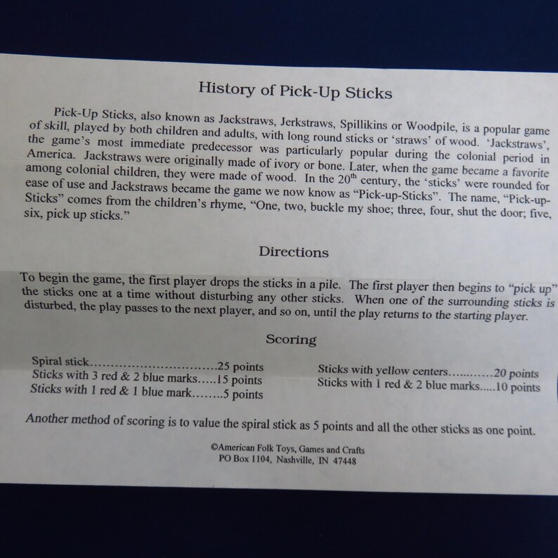 May include: A printed sheet with the history, directions, and scoring for the game Pick-Up Sticks. The text includes details on the game's origins, rules, and point values for different stick types. The game is also known as Jackstraws.