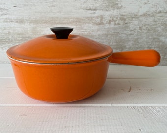 casserole vintage Le Creuset dans la batterie de cuisine classique emblématique Volcanic Orange des années 1970. Taille 20 avec couvercle.