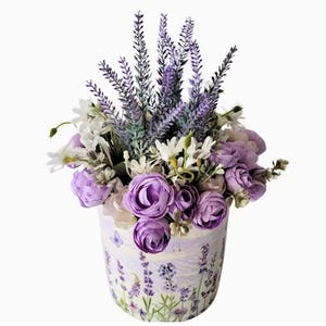 May include: A purple and white floral arrangement in a ceramic pot with a lavender print. The arrangement features lavender, white daisies, and purple roses.