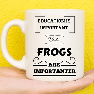 Puede incluir: Taza de cerámica blanca con texto negro que dice "La educación es importante, pero... Las ranas son más importantes."