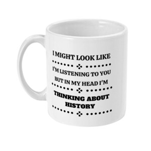 K&ouml;nnte beinhalten: Wei&szlig;e Keramik-Kaffeetasse mit schwarzem Text, der lautet: "Ich mag aussehen, als w&uuml;rde ich zuh&ouml;ren, aber in meinem Kopf denke ich &uuml;ber Geschichte nach."