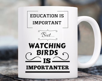May include: White ceramic coffee mug with black text that reads "Education is important, but watching birds is importanter."