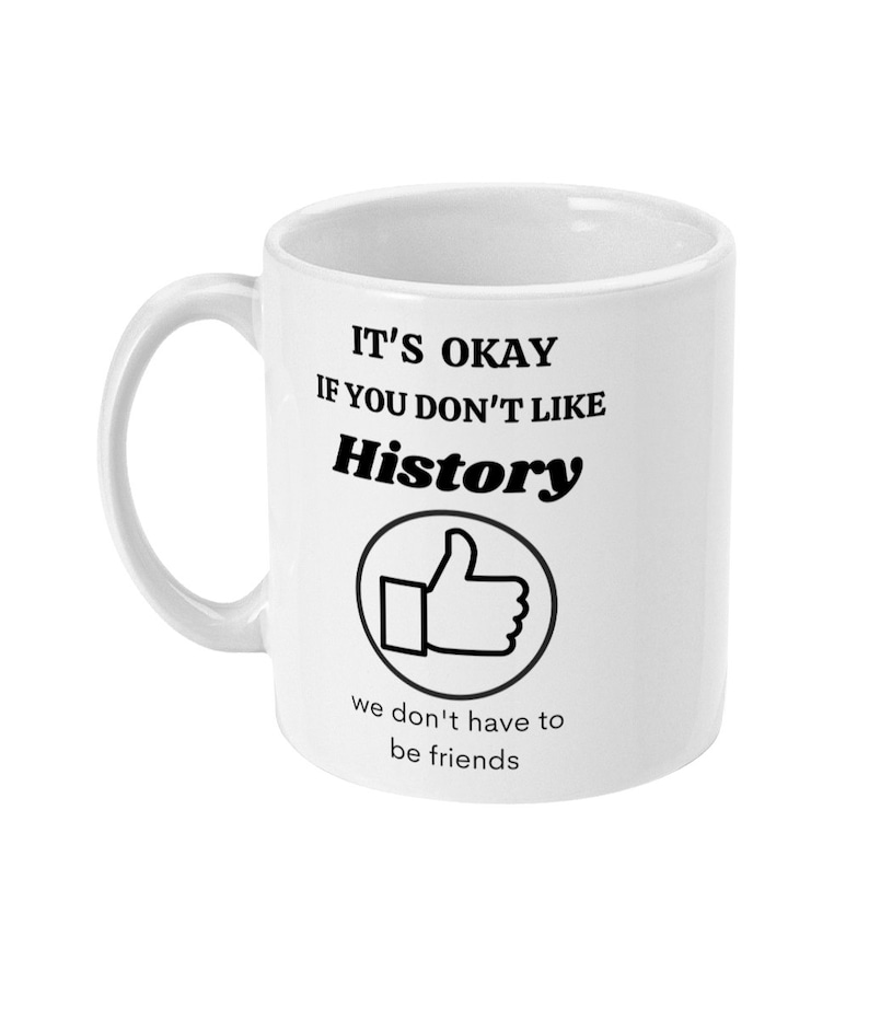 K&ouml;nnte beinhalten: Eine wei&szlig;e Keramiktasse mit schwarzem Text, der "It's okay if you don't like History" lautet, mit einem Daumen-hoch-Symbol und dem Text "we don't have to be friends".