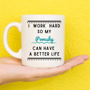 May include: White ceramic mug with black text that reads "I work hard so my Pomsky can have a better life".
