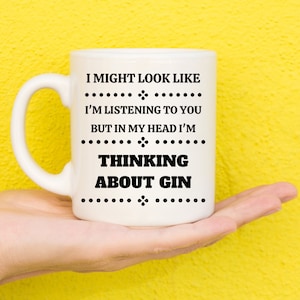 May include: White ceramic mug with black text that reads "I might look like I'm listening to you but in my head I'm thinking about gin".