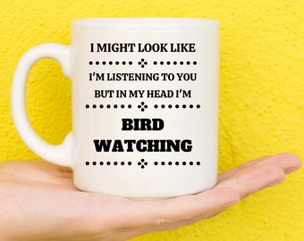May include: White ceramic mug with black text that reads "I might look like I'm listening to you but in my head I'm bird watching".