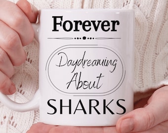 Può includere: Tazza da caffè in ceramica bianca con testo nero che recita "Forever Daydreaming About SHARKS".