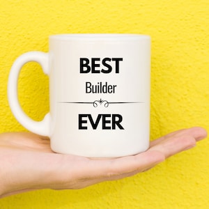 May include: White ceramic mug with black text that reads "BEST Builder EVER".