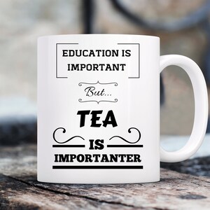 May include: White ceramic mug with black text that reads "Education is important, but... Tea is importanter".