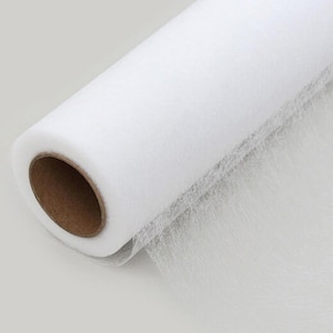 May include: A roll of white tulle fabric, partially unrolled, revealing a delicate, sheer texture. The fabric is wrapped around a brown cardboard core. Ideal for crafting and decorative projects.